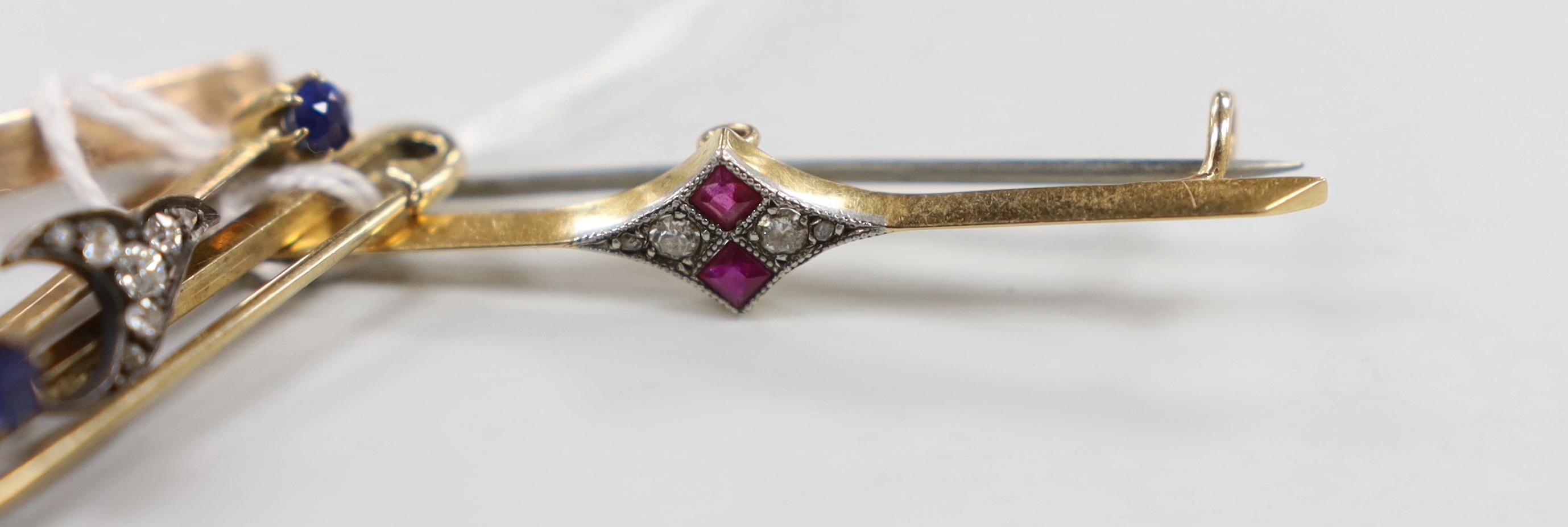 An Edwardian 15ct, ruby and diamond set bar brooch, 48mm, gross weight 3.3 grams, a similar yellow metal, sapphire and diamond cluster set bar brooch and two 9ct bar brooches, gross weight 9.3 grams.